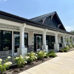 Modern commercial building exterior with large windows and a covered walkway, resembling the style of Michigan modular homes.